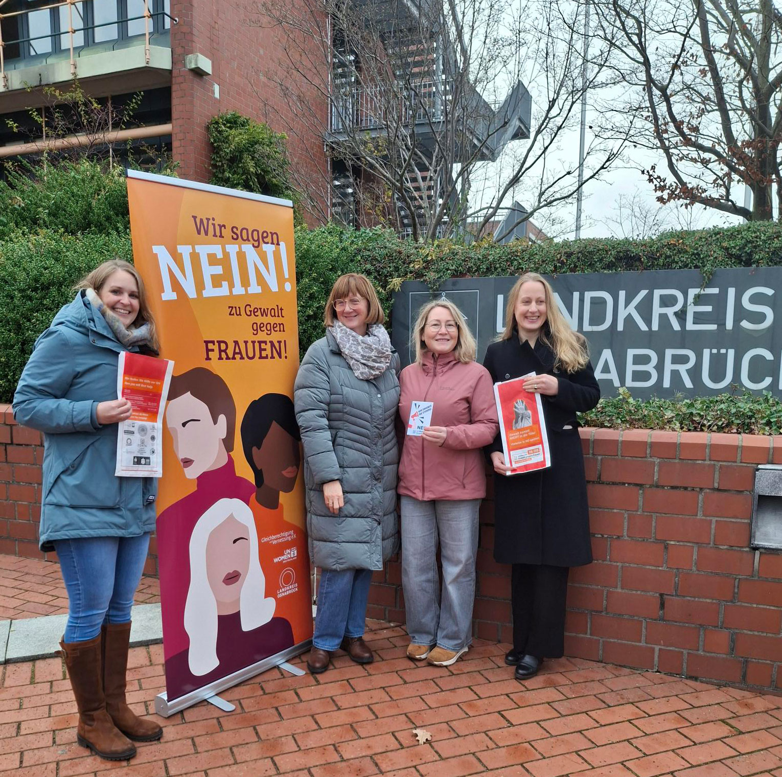 Das Team steht mit Frau Ottens und Landrätin Kebschul vor dem Landkreisgebäude