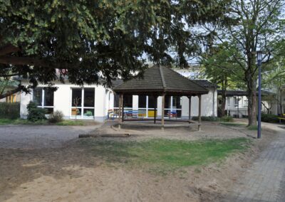 überdachte Sitzecke auf einem Sandplatz