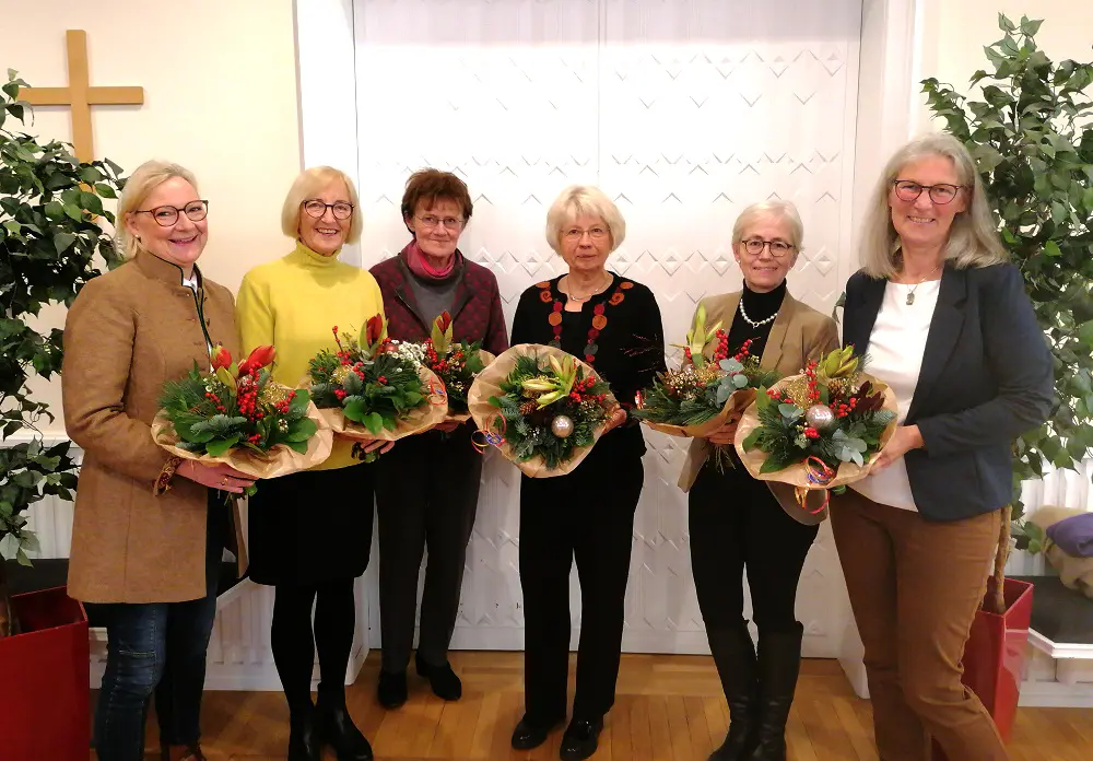 Der neue Vorstand steht mit Blumensträußen nebeneinander