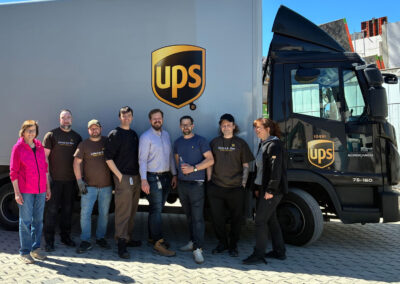 Das UPS-Team steht vor dem Gebäude