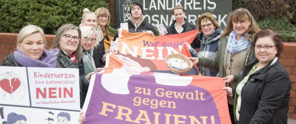Personen stehen mit einem Banner in der Hand