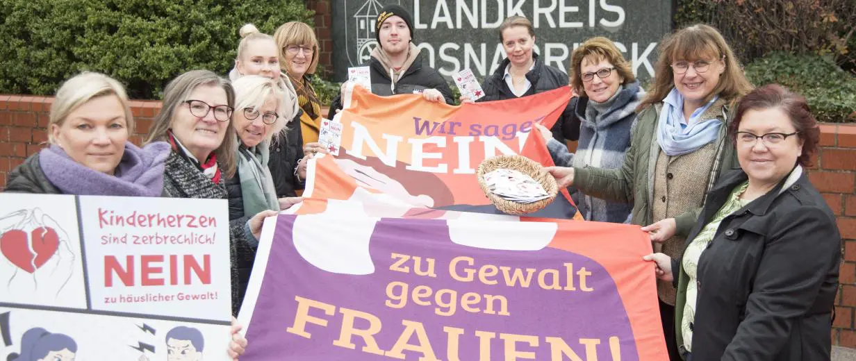Personen stehen mit einem Banner in der Hand