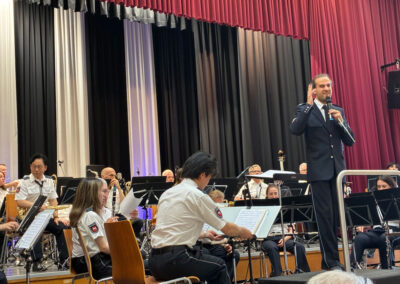 Der Dirigent steht vor dem Orchester und begrüßt die Zuhörer.